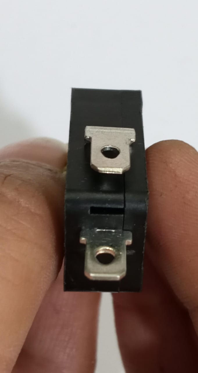 Limit switch - a close-up view of the black plastic body showing two metal spade terminals held between fingers.