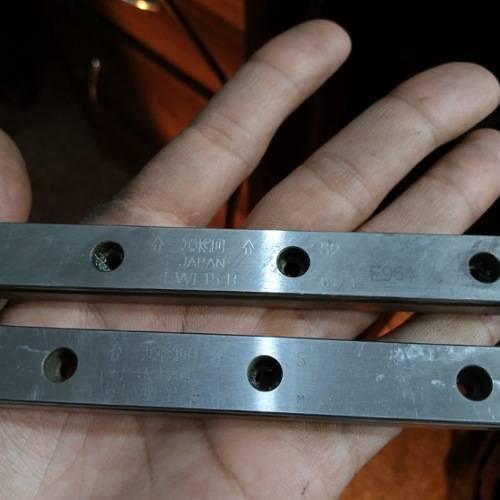 Linear Bearing Slide Rail CNC Router - a close-up showing two silver metal rails with mounting holes and engraved text including "JAPAN" and "LWI 15 R".