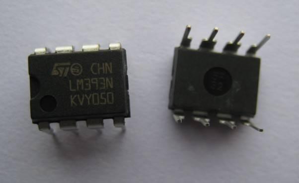 LM393 Dual Differential Comparator IC - shown as two black, eight-pin integrated circuit chips with white text markings on a plain white background.