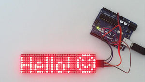 MAX7219 32×8 Dot Matrix Display Module - connected to an Arduino board, showing the red illuminated text "Hello :)" on its LED matrix display.