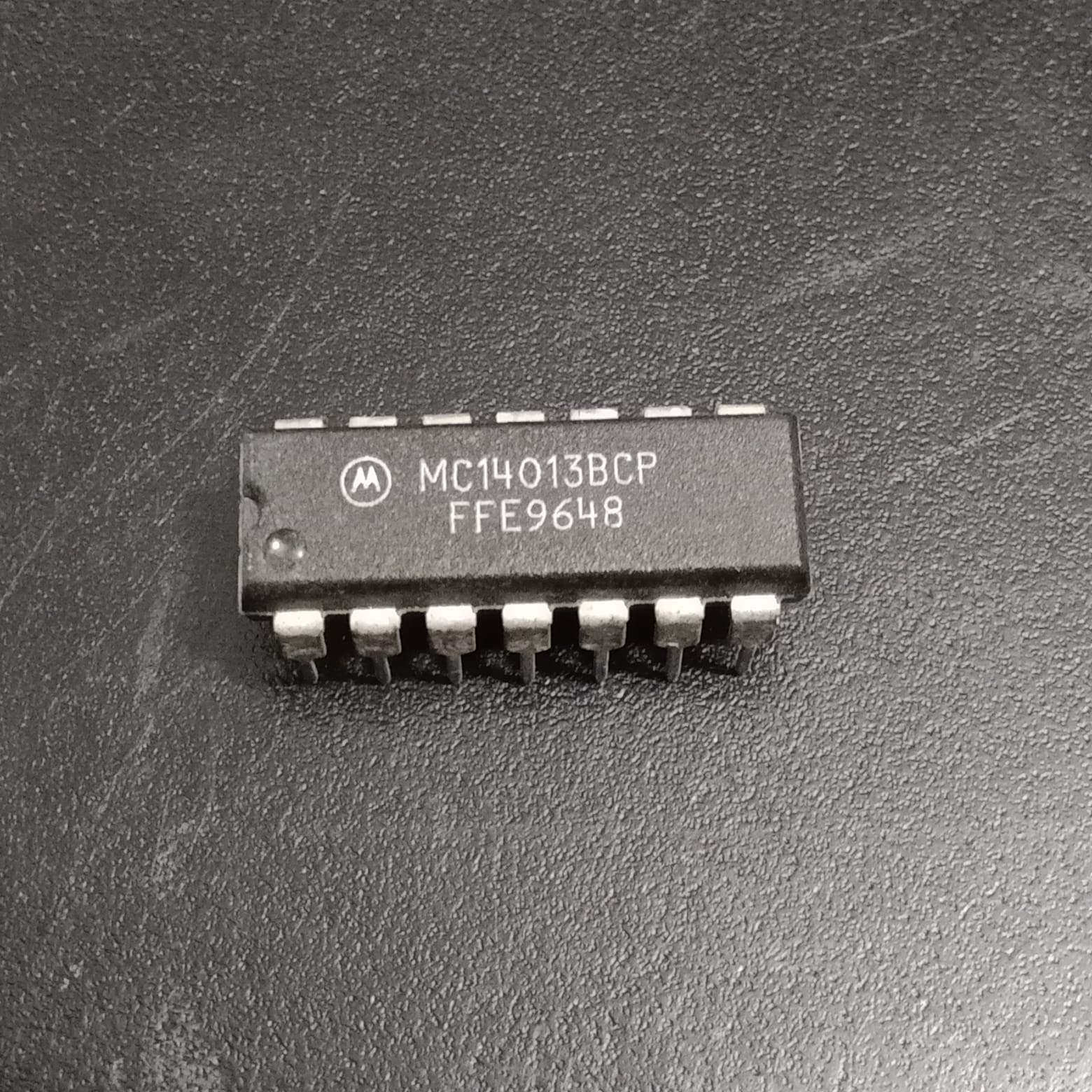 MC14013BCP Dual D-Type Flip-Flop IC - a black 14-pin integrated circuit chip with white text markings on its surface, shown in a top-down close-up view.