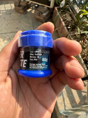 Mechanic LW50 Solder Paste 138°c Low Temp 50G - a blue plastic jar held in a hand, showing the label with alloy Sn42Bi58, micron 4#, and flux IPX4 specifications.