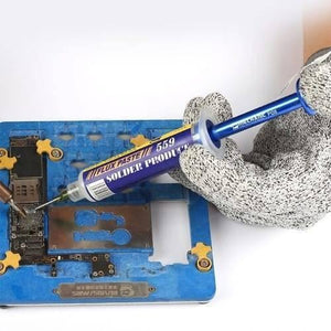 Mechanic P08 Aluminum Alloy Needle Tube Piston Solder Paste Flux Welding Oil Booster Pusher - a blue aluminum alloy syringe tool held by a gloved hand, applying flux paste to a circuit board on a blue jig.