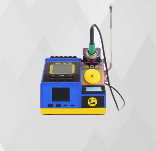 MECHANIC PRIME NANO SOLDERING STATION - blue and yellow soldering station with a digital screen, black control buttons, an iridescent tool holder, a yellow circular dial, and a small bearded man logo.
