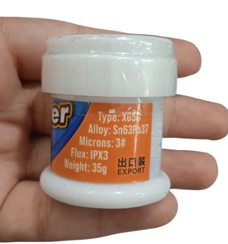 Mechanic Solder Paste 35G XG50 183C - shown in a white plastic jar held in a hand, with an orange label detailing alloy, micron, and flux specifications.