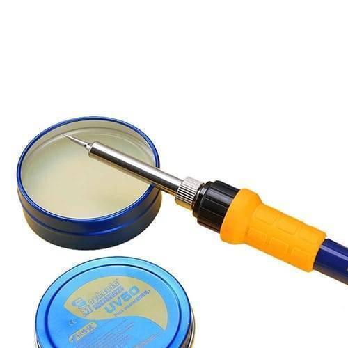 Mechanic Soldering Flux Paste PCB BGA Welding Flux Gel Tin MCN-UV50 - shown with a soldering iron tip touching the open flux container and a closed blue tin container in the foreground.