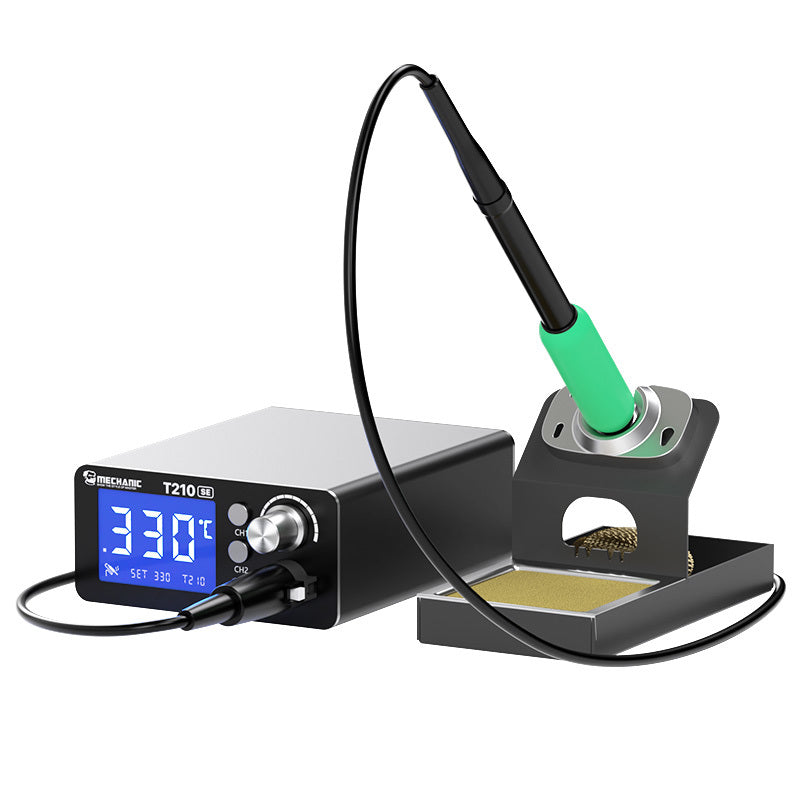 MECHANIC T210 SE THERMOSTATIC SOLDERING STATION - silver and black digital soldering station with a blue LCD screen, a green-handled soldering iron, and a black stand containing a brass wire sponge and tray.