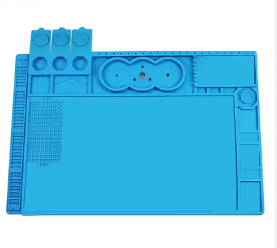 MECHANIC V56 HEAT INSULATION MAT - rectangular bright blue silicone work mat featuring a grid section, various recessed tool organizers, and circular screw compartments on a white background.