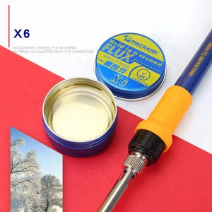 MECHANIC X6 FLUX PASTE 20GRAM - Soldering Flux - a round blue tin containing yellow soldering flux, with its blue and yellow branded lid nearby, next to a blue and yellow soldering iron.