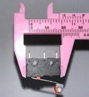 Micro Roller Lever Arm Open Close Limit Switch Micro Switch - shown in a close-up view being measured by pink plastic digital calipers.