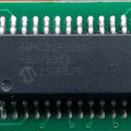 Microchip DSPIC30F2010 Microcontroller - 14-bit DSC with DSP - a black integrated circuit chip with 28 pins soldered onto a green printed circuit board.
