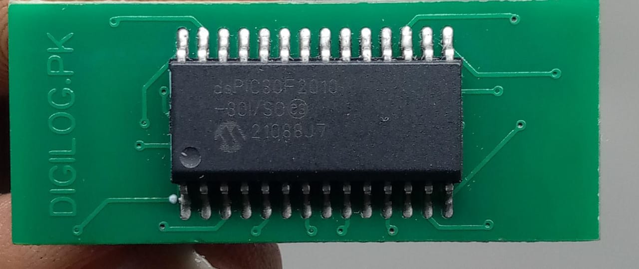Microchip DSPIC30F2010 Microcontroller - 14-bit DSC with DSP - a black integrated circuit chip soldered onto a green rectangular printed circuit board with visible traces.