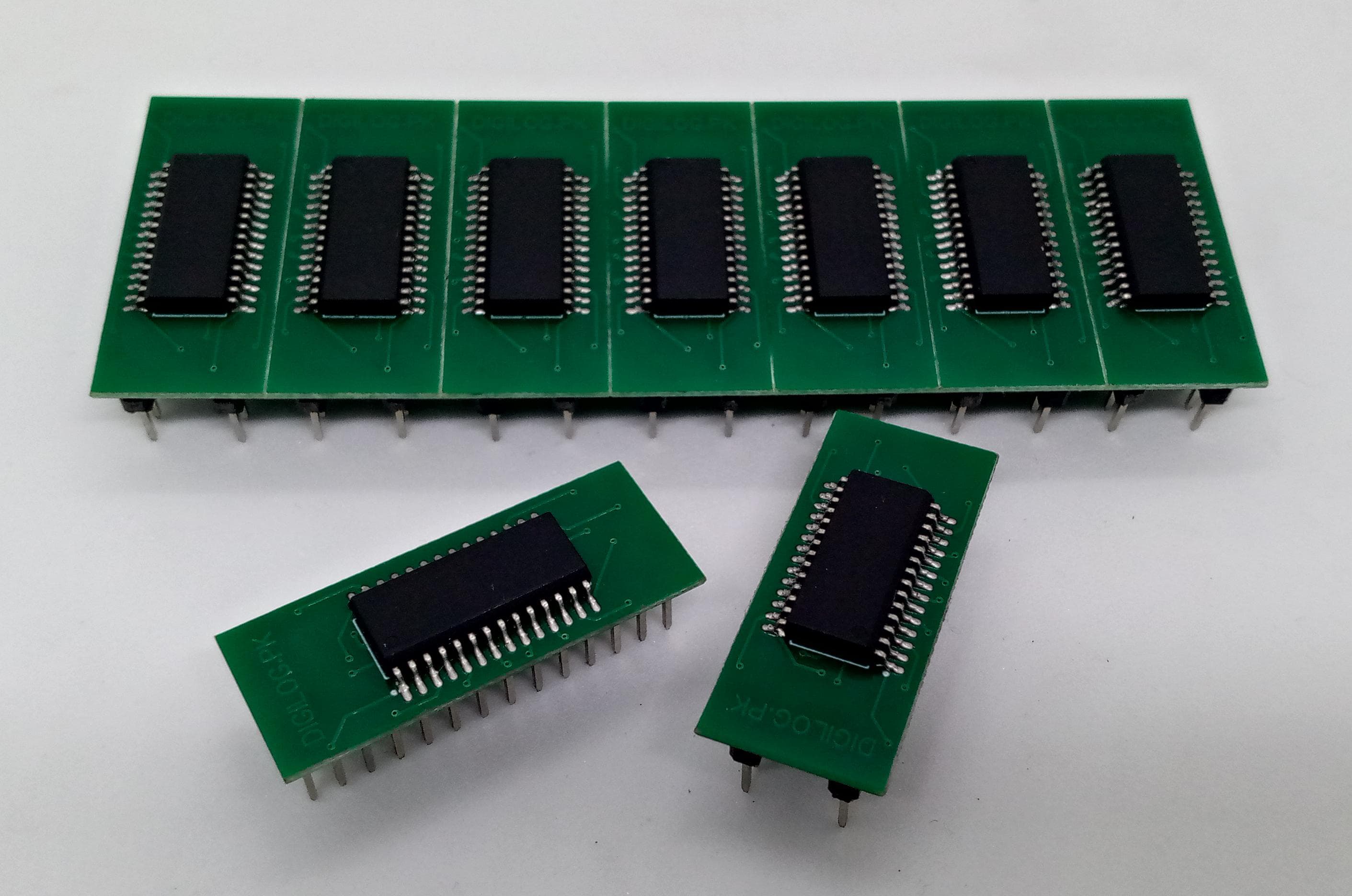 Microchip DSPIC30F2010 Microcontroller - 14-bit DSC with DSP - shown as seven chips mounted on green circuit boards in a row, with two additional boards placed in the foreground.