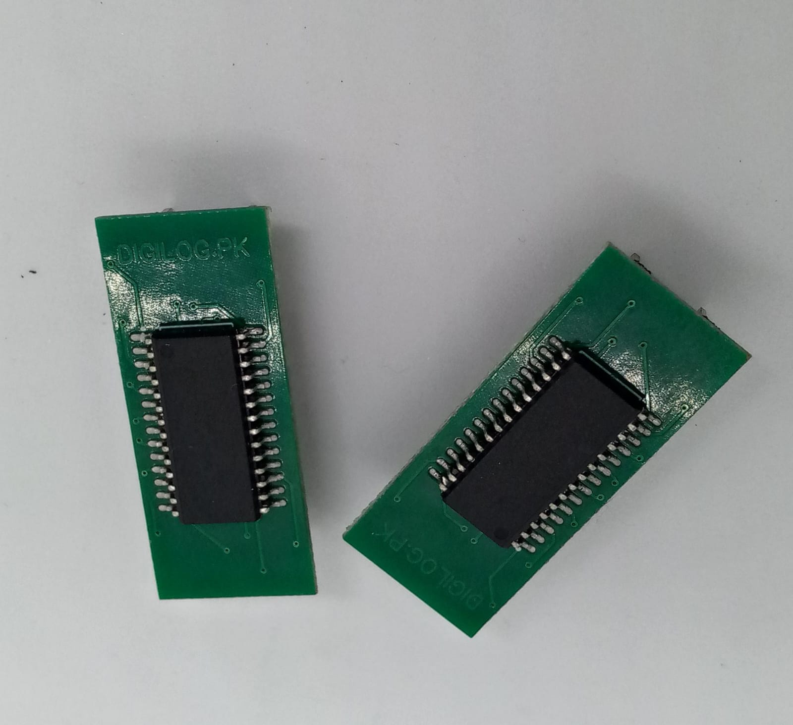 Microchip DSPIC30F2010 Microcontroller - 14-bit DSC with DSP - two green rectangular circuit boards with black integrated circuits mounted on the top surface.