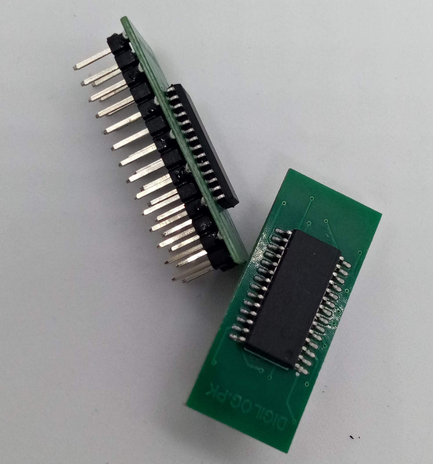 Microchip DSPIC30F2010 Microcontroller - 14-bit DSC with DSP - two green printed circuit boards with black integrated circuits and rows of metal connector pins.