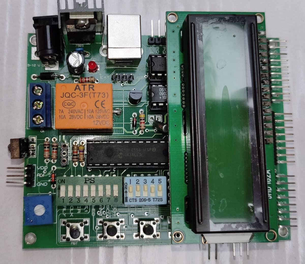 Microchip Pic Lab-ii Development Board 28 Pin Microcontrollers - a green PCB, an LCD screen, an orange relay, push buttons, and DIP switches.