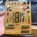 MikroDuino-II AVR ATMEGA32 Arduino Compatible Board Without LCD ,IC And Arduion - a yellow circuit board with a 40-pin IC socket, multiple pin headers, LED indicators, and buttons, held in a hand.