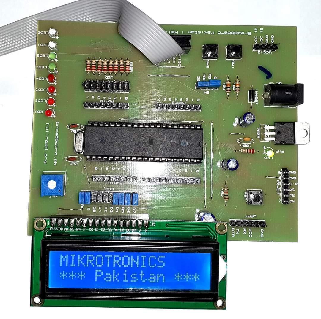 Mikroduino Kiwi Avr ATMEGA32 Arduino Ready Development Board Without LCD Without Microcontroller - an LCD screen displaying "MIKROTRONICS *** Pakistan ***", LEDs, buttons, and power ports.