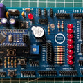 Mikroduino Nano — Arduino Nano Trainer Development Board And Learning Shield Board Made - a blue rectangular circuit board featuring an Arduino Nano, a buzzer, ten red LEDs, a potentiometer, and headers.