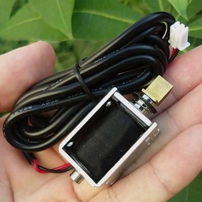 Mini 12V DC Electric Cabinet Door Lock Electromagnet Push Pull Type - a silver metal frame, black coil, brass plunger, and a white connector.