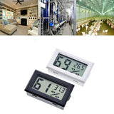Mini Digital Thermometer Hygrometer Temperature Humidity Meter Fy-11 - one black and one white unit, each with a digital display showing humidity and temperature readings.