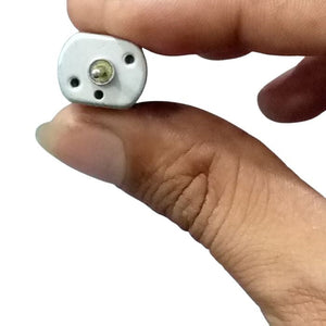 Mini Flat 030 Electric Motor DC 12V-24V 19500RPM Dual Axle Shaft - a close-up view of the silver, rectangular motor face being held by fingers.