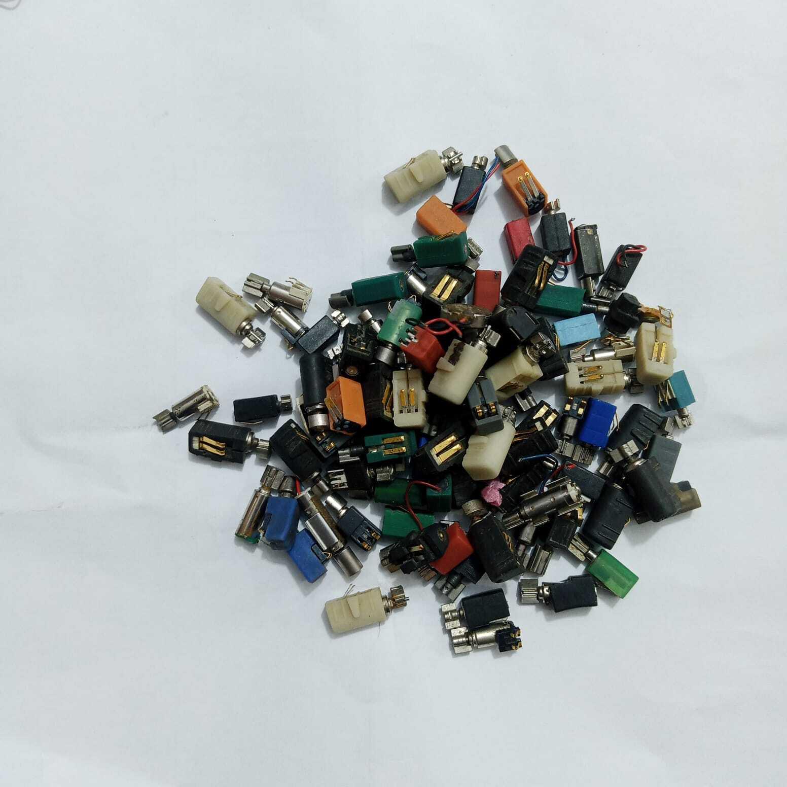 Mini Vibration Motor MT35 3V - shown as a large, scattered pile of various small cylindrical vibration motors with colourful plastic casings and metal tips.