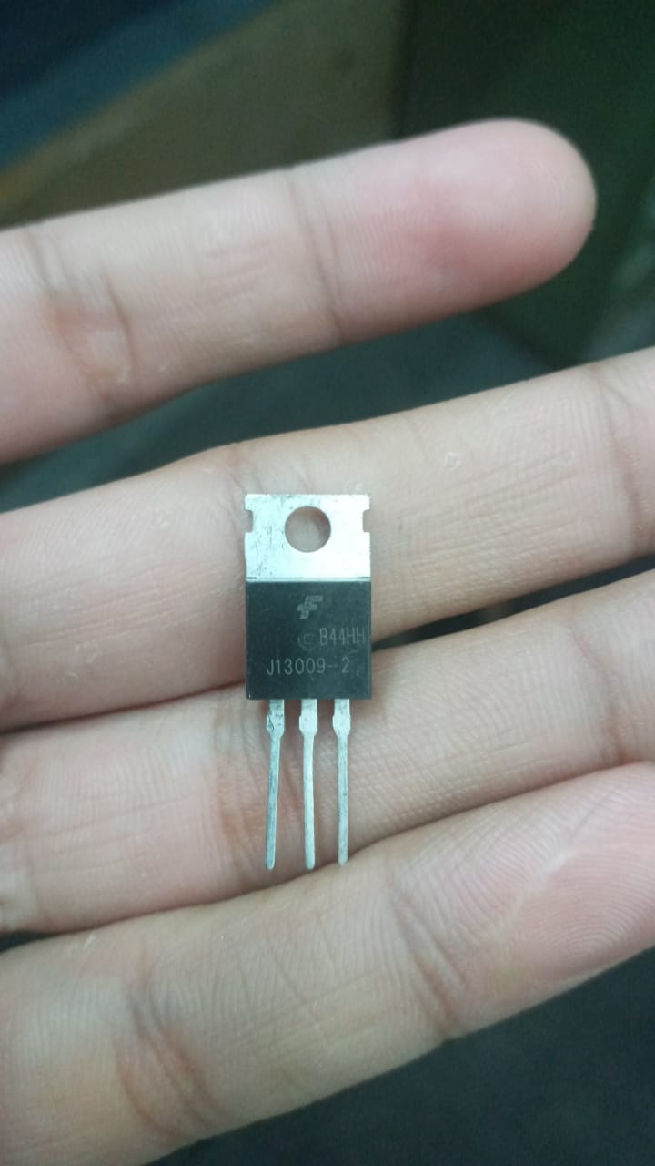 MJ13009 Transistor High Performance NPN Transistor for Electronics Projects - a black three-pin NPN transistor held between fingers, showing the J13009-2 and B44HH markings on its front surface.