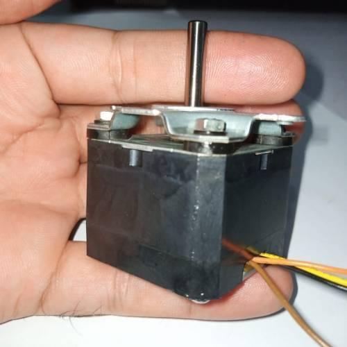 ML17A3 Bipolar NEMA17 Stepper Motor With Shock Absorber - a black square motor with a silver shaft and attached wires, held in a hand.