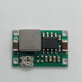 MP1482 Mini 360 2A DC-DC Step-down Converter - Efficient Voltage Regulation For Your Electronics - a green circuit board, a square inductor, an integrated circuit chip, and a small potentiometer.