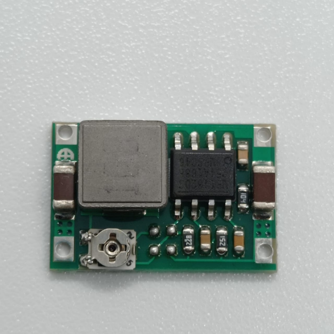 MP1482 Mini 360 2A DC-DC Step-down Converter - Efficient Voltage Regulation For Your Electronics - a green circuit board, a square inductor, an integrated circuit chip, and a small potentiometer.