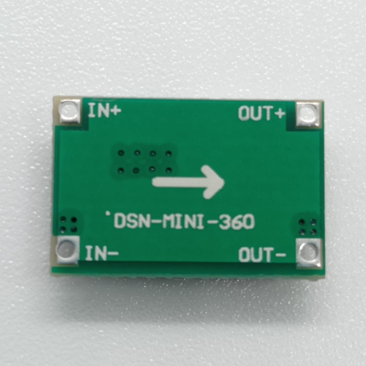 MP1482 Mini 360 2A DC-DC Step-down Converter - Efficient Voltage Regulation For Your Electronics - a small rectangular green circuit board with four corner solder pads labeled IN+, IN-, OUT+, and OUT-.