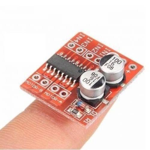 MX1508 Mini Dual Channel 1.5A DC Motor Driver Module Mini L298N Replacement - a small red circuit board with two silver capacitors, an integrated chip, and labeled connection pins.