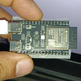 Front of the nanoESP32-C6 board held in hand, showing the BOOT and RST buttons, COM and USB Type-C ports and GPIO silkscreen