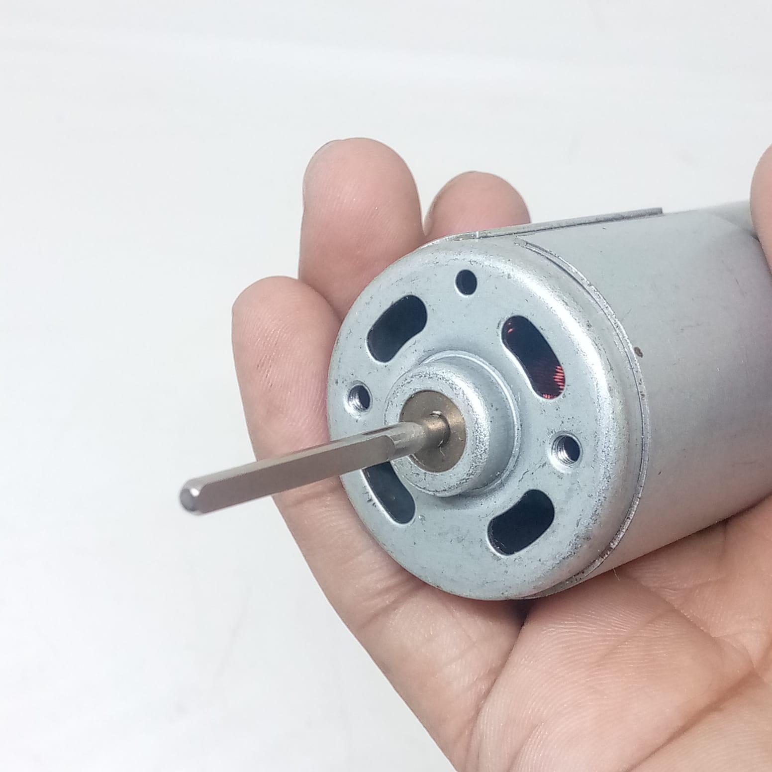 Narrow Shaft Motor 3.17mm Shaft 12V Charger Fans DC Motor - a close-up of a silver cylindrical DC motor with a flat-sided metal shaft held in a hand.