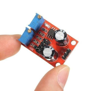 NE555 Pulse Frequency Duty Cycle Adjustable Module Square Wave Signal Generator - a red circuit board with two blue potentiometers, two capacitors, and a three-pin connector.