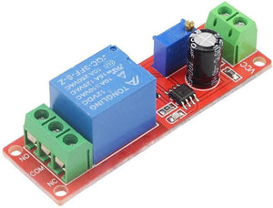 NE555 Timer Switch Adjustable Module Time Delay Relay Module DC 12V - a red circuit board featuring a blue relay, a black capacitor, a blue potentiometer, and green terminal blocks.