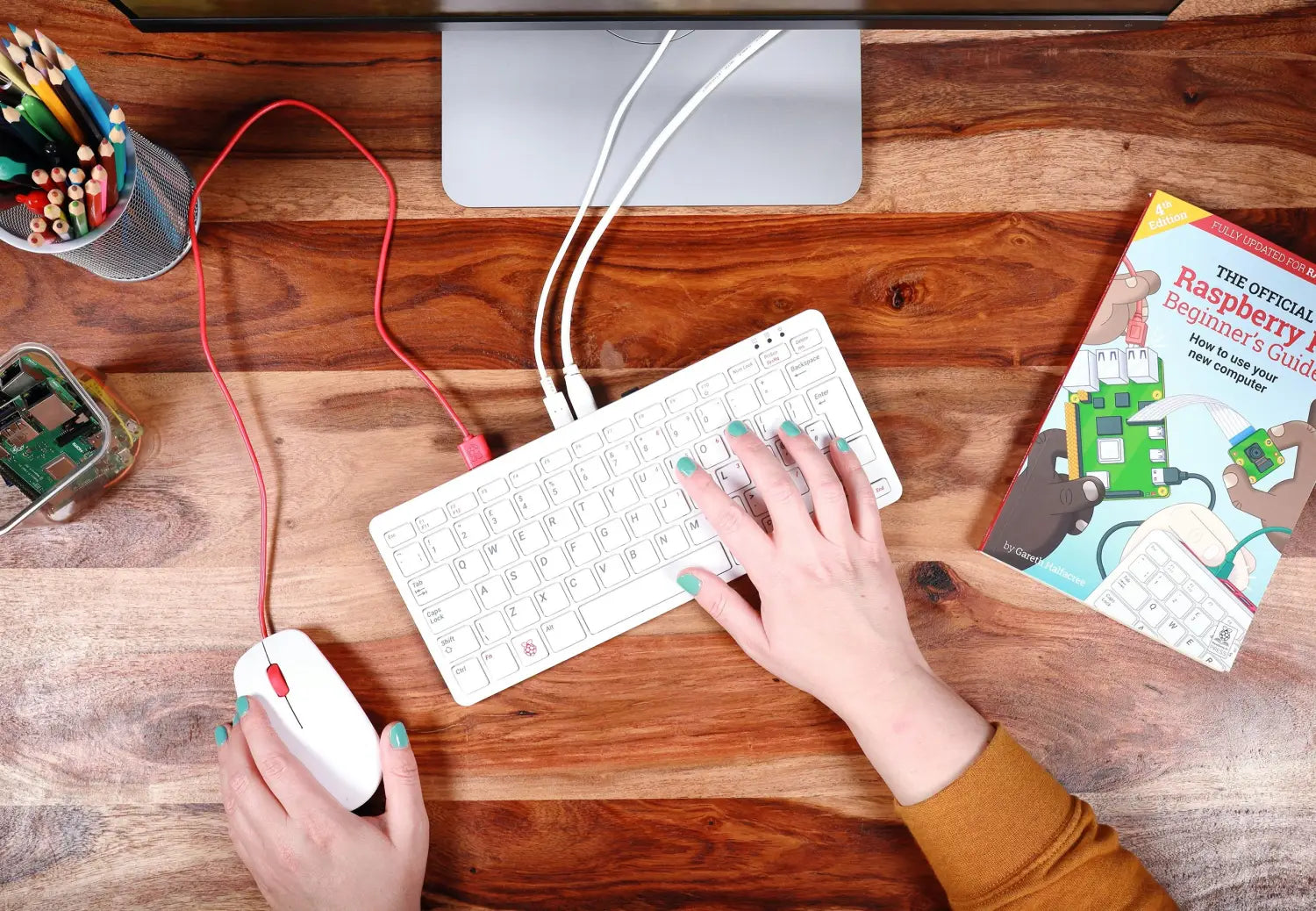 A Raspberry Pi 400 in use on a desk, with a mouse and monitor connected