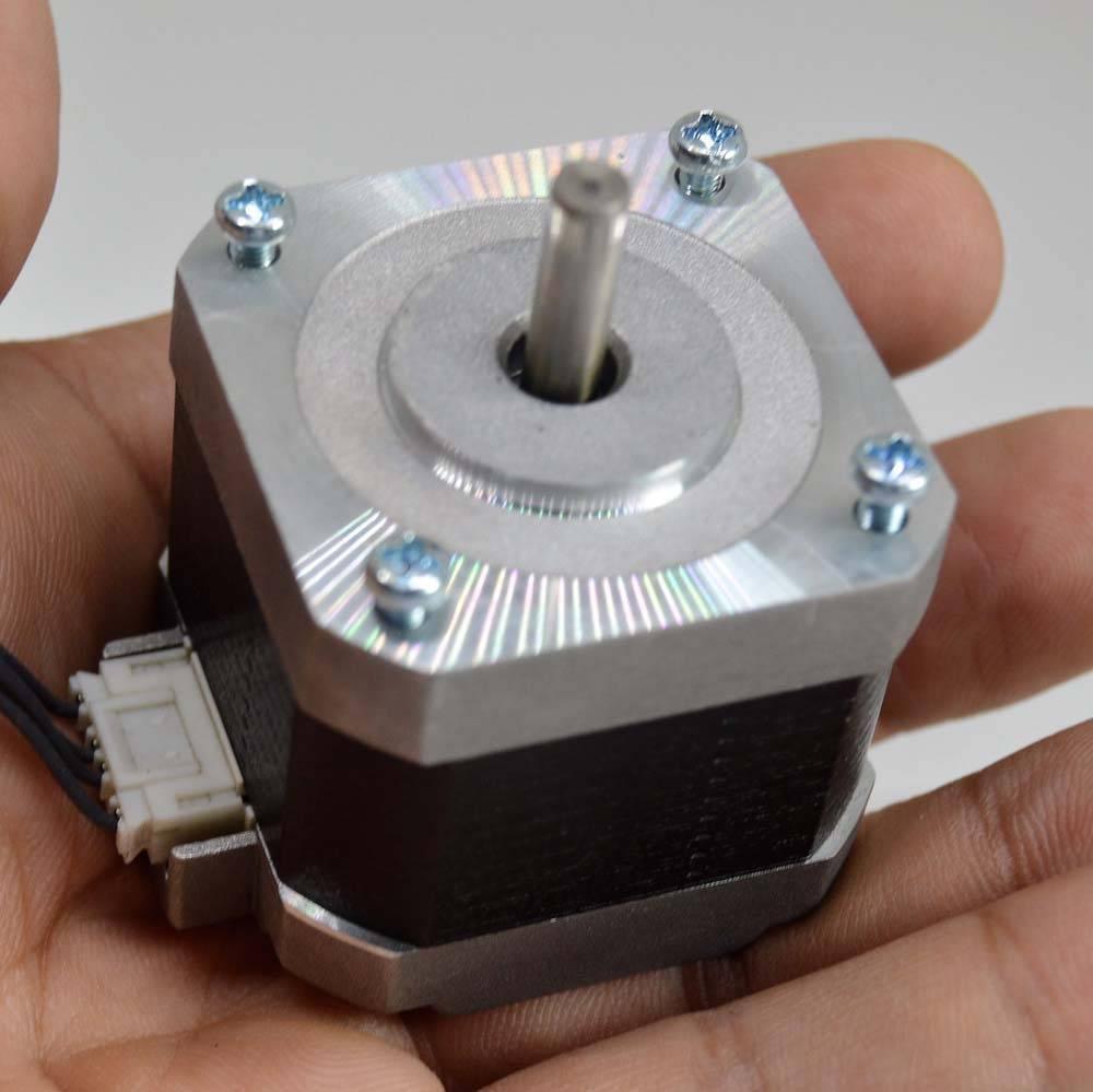 NEMA 17 4 Wire Stepper Motor NEMA17 Stepper Motor REFIRBISHED - shown as a silver and black square motor held in a hand with a central shaft and a white connector port.