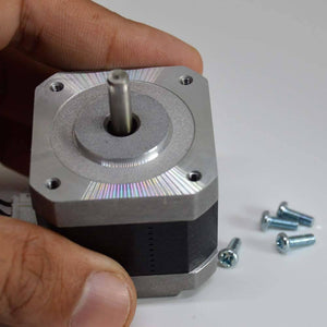 NEMA 17 4 Wire Stepper Motor NEMA17 Stepper Motor REFIRBISHED - shown being held by a hand, featuring a silver metal front plate, a central shaft, and four loose mounting screws.