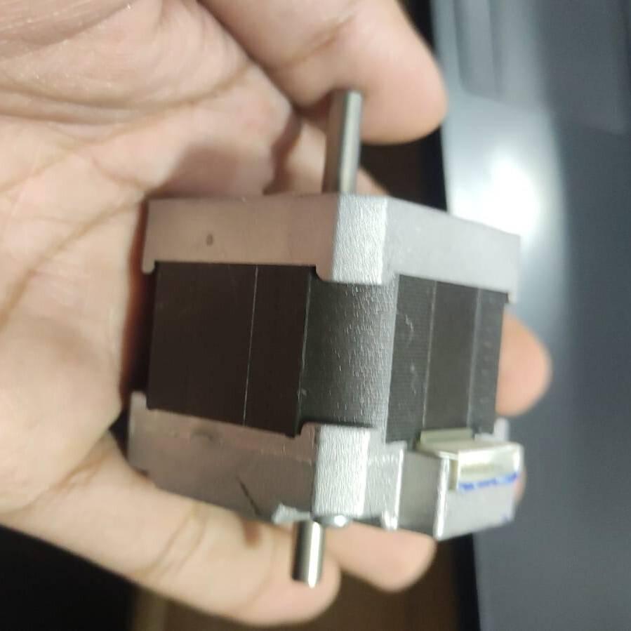 NEMA 17 Stepper Motor Dual Shaft Model B-2381715B - shown held in a hand, featuring a black square body, silver end caps, dual shafts, and a white connector.