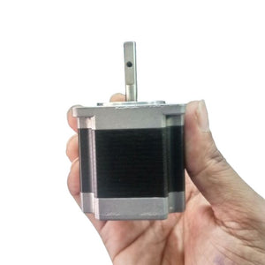 NEMA 20 Stepping Motor – Precision Control for Robotics, CNC & Automation | Digilog.pk - held in a hand, showing the silver metal casing, black motor body, and a single vertical shaft with a small hole.