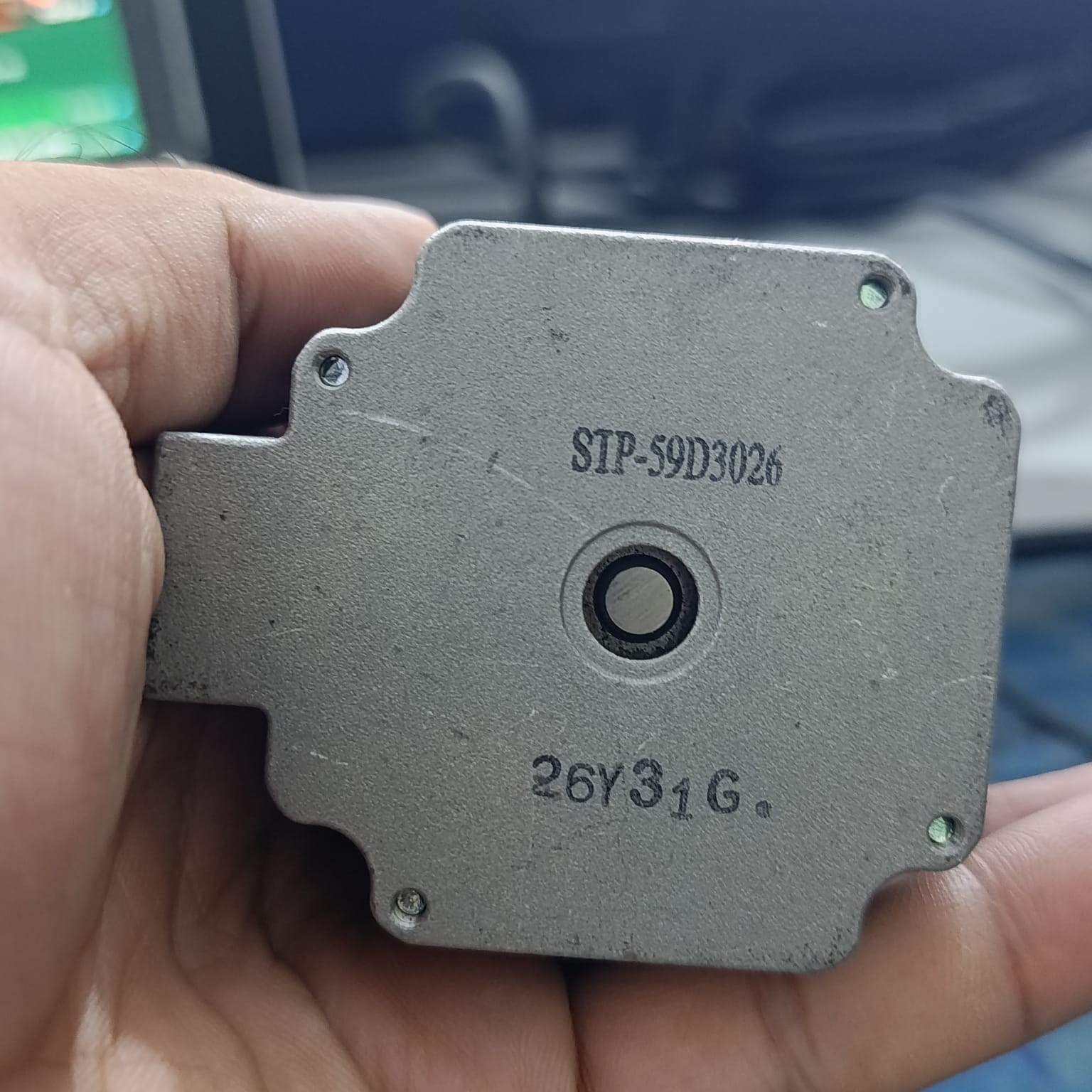 NEMA 23 Stepper Motor In Pakistan (1.5A–2.0A, 1.8°) - a close-up of the silver metal face showing the centered shaft hole and the printed text STP-59D3026 and 26Y31G.