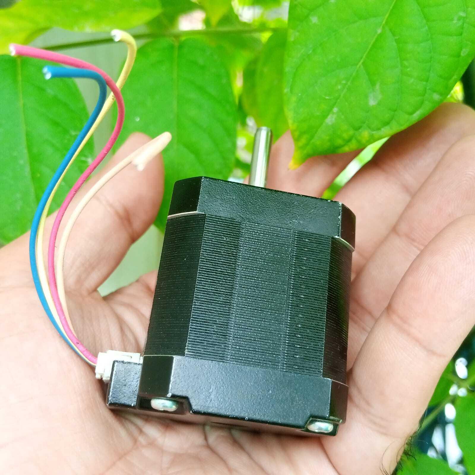 NEMA17 Stepper Motor 1.5A Maximum 48mm Height A4988 DRV8825 Compatible Bipolar Stepper Motor - a black square-bodied motor with a silver shaft and four multi-coloured wires connected to a white plastic plug, held in a hand.