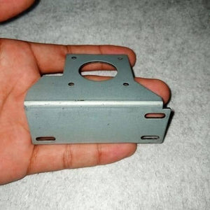 NEMA17 Stepper Motor Mounting Bracket NEMA17 Fitting - a grey L-shaped metal bracket with a circular center hole and four mounting slots, held in a hand.