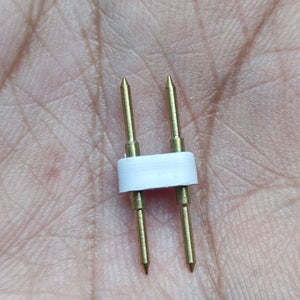 Neon Light Connector Pin - a close-up showing a small white plastic piece holding two parallel gold-coloured metal pins against a palm.