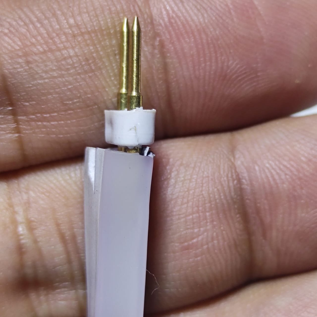 Neon Light Connector Pin - a close-up showing a white plastic connector with two gold-coloured metal pins attached to a piece of white LED neon strip.