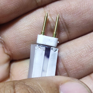 Neon Light Connector Pin - a close-up view of a white plastic connector with two gold-coloured metal pins held between fingers.