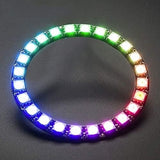 NeoPixel Ring 24bit WS2812 5050 RGB LED - Full Color Programmable Light - a circular circuit board with 24 individual LEDs illuminated in a multi-colored gradient against a dark background.