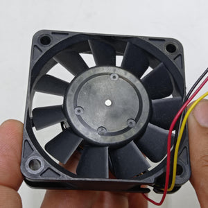 NEW 24V 60mm x 60mm x 15mm Brushless DC Cooling Fan - a black square-framed fan with eleven blades held by two hands, showing red, yellow, and black wires.